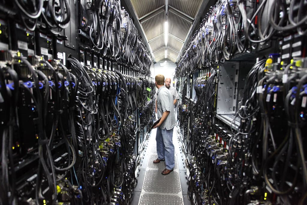 Technicians working between rack rows in a data center environment