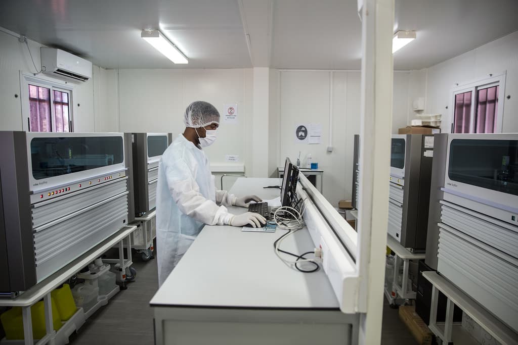 Laboratory technician operating diagnostic equipment in a controlled testing room